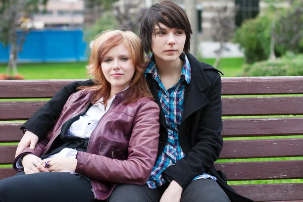 Two girl friends sitting on a park bench — Stock Photo, Image