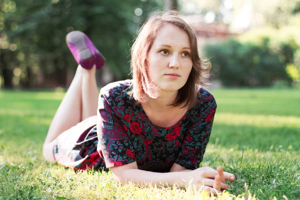 Junge Frau liegt auf dem Gras — Stockfoto