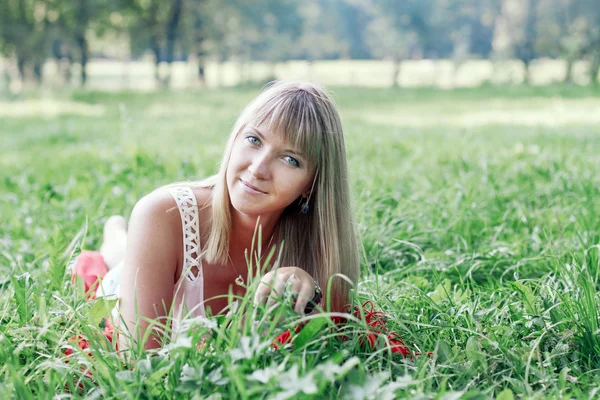 Junge Frau liegt auf dem Gras — Stockfoto