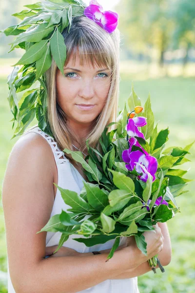 Jonge vrouw krans van bloemen en boeket dragen — Stockfoto