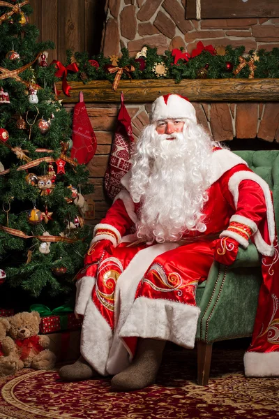 Alegre Papai Noel sentado em sua cadeira — Fotografia de Stock