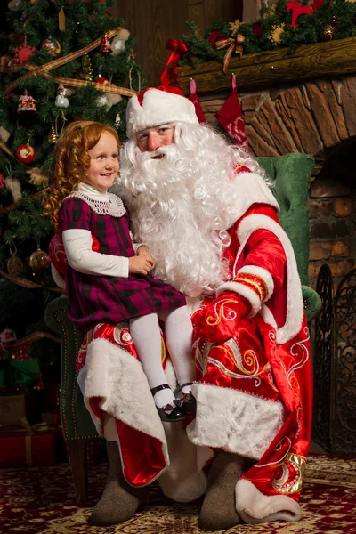 Noel Baba bir kız ile bir sandalyede oturuyor. — Stok fotoğraf