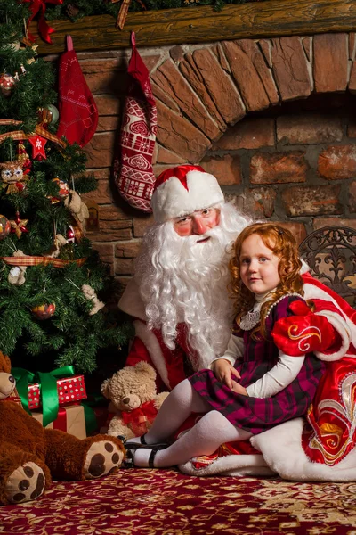 Santa Claus sedí s malou holčičkou. — Stock fotografie