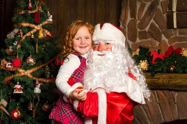 Santa Claus holds on hands happy little girl. — Stock Photo, Image
