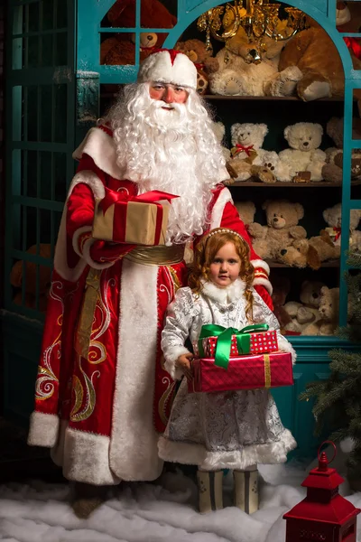 Дед Мороз и Снегурочка стоят с подарками — стоковое фото