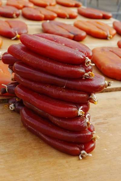 Pile of dried grey mullet roe on boards with sunlight — Stock Photo, Image