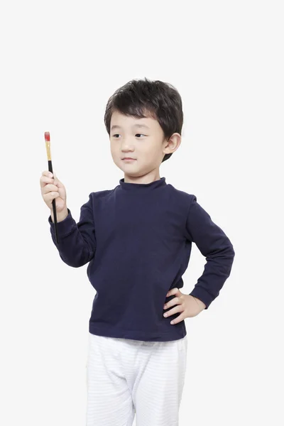 One asian boy child holds painting brush with white background — Stock Photo, Image