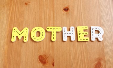 MOTHER, spell by woody puzzle letters with woody background clipart