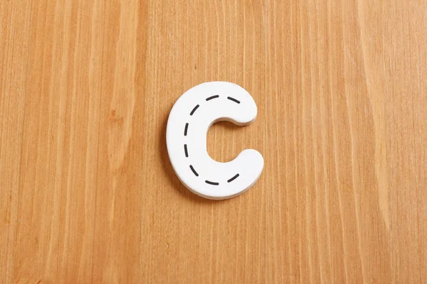 C, incantesimo da lettere di puzzle legnose con sfondo legnoso — Foto Stock