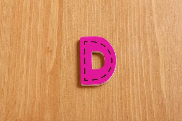 D, spell by woody puzzle letters with woody background — Stok Foto