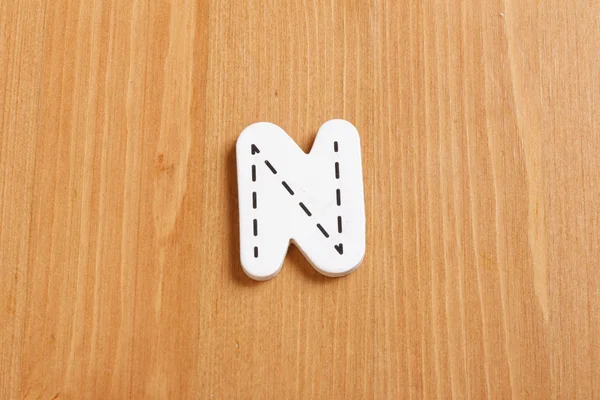 N, spell by woody puzzle letters with woody background — Stok Foto