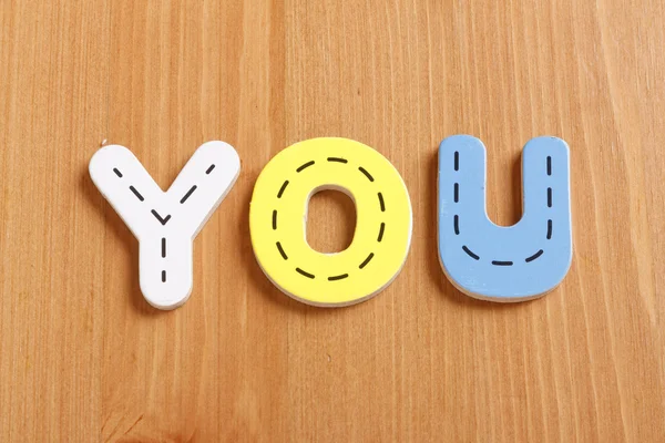 YOU, spell by woody puzzle letters with woody background — Stock Photo, Image
