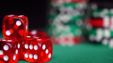 Yeşil masada kırmızı zar ve casino fişleri