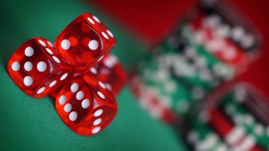 Yeşil masada kırmızı zar ve casino fişleri