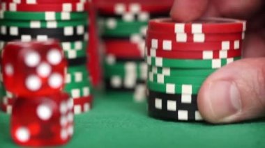 Yeşil tablo parmaklar kırmızı zar ve casino fişleri