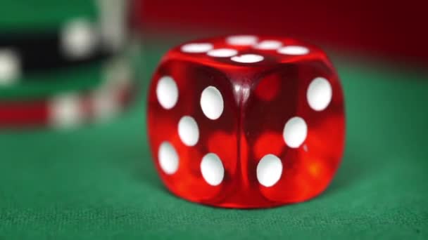 Rode dobbelstenen rotatie en casino chips op de groene vilt — Stockvideo
