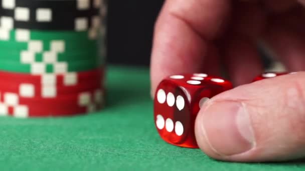 Dados vermelhos e fichas de casino na mão na mesa verde — Vídeo de Stock