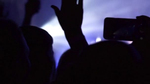 A fazer uma festa num concerto de rock. Mãos seguram câmeras com displays digitais em concerto de rock — Vídeo de Stock