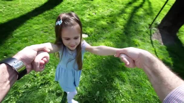 Petite fille filant dans les mains des parents sur le coucher du soleil — Video