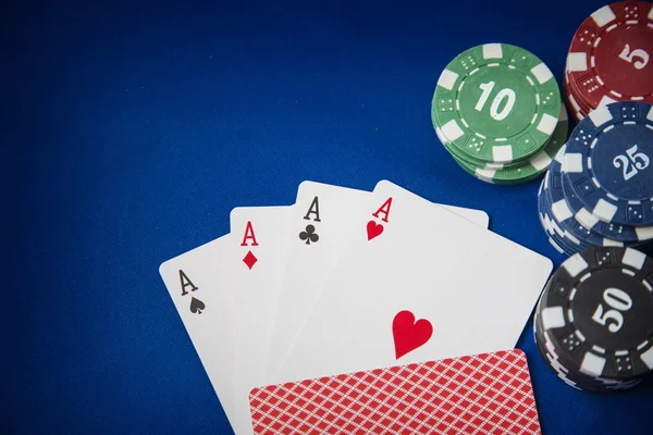 Fichas de jogo e cartão de poker no fundo feltro azul — Fotografia de Stock