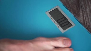 Erkek bacaklar ayakta üzerinde bir ev kat ağırlık ölçekler