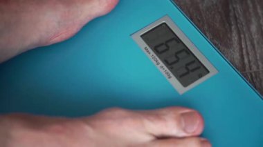 Erkek bacaklar ayakta üzerinde bir ev kat ağırlık ölçekler