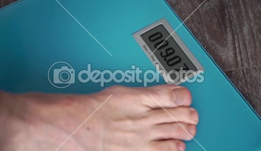 Erkek bacaklar ayakta üzerinde bir ev kat ağırlık ölçekler ve üzerinde ekran go Run