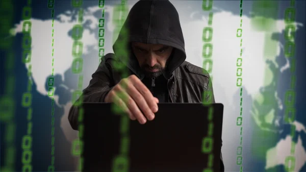 Cara de hacker en una capucha con portátil. Peligro red en línea . — Foto de Stock