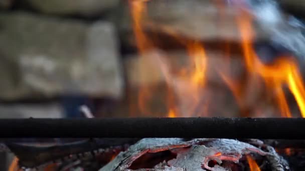 Flamme de feu de joie close-up dans la lumière du jour avec fond de pierres — Video