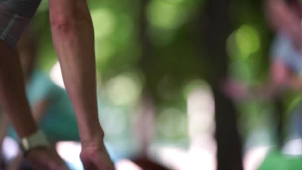 Primer plano instructor de fitness haciendo ejercicio en el parque con el grupo — Vídeos de Stock