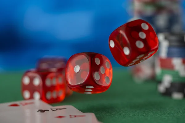 Dados vermelhos gira no ar, fichas de casino, cartões em feltro verde — Fotografia de Stock