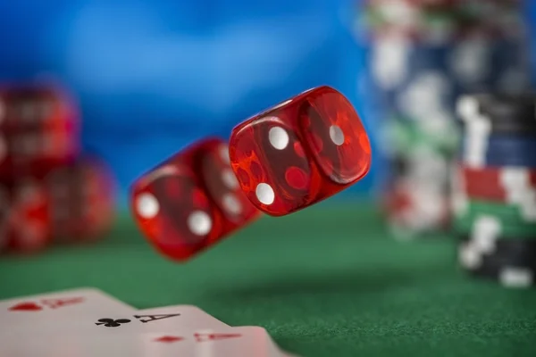 Fichas de casino, cartões e dois dados vermelhos na mesa de jogo de feltro verde — Fotografia de Stock