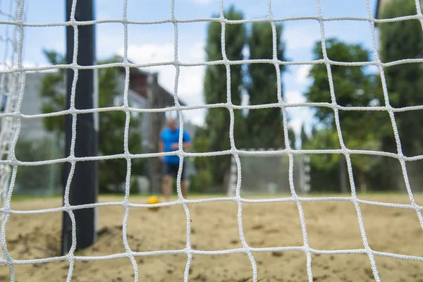 Пляжный футболист через сетку. Игры Рио . — стоковое фото
