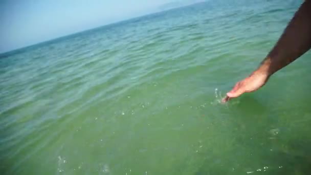 Poner la mano masculina en el agua, disparar en cámara lenta — Vídeo de stock