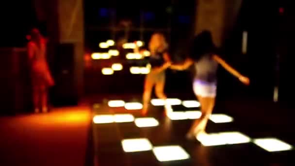 Dance floor in a disco club with young women dancing with defocused background — Stock Video