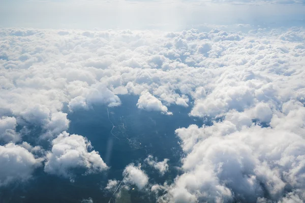 Mraky, země, slunce a oblohu, jak je vidět v okně letadla — Stock fotografie