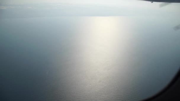 Ουρανός και θάλασσα με αντανάκλαση, όπως φαίνεται στο παράθυρο του αεροσκάφους — Αρχείο Βίντεο