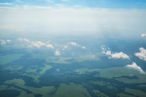 Mraky, nebe a země, jak je vidět v okně letadla — Stock fotografie