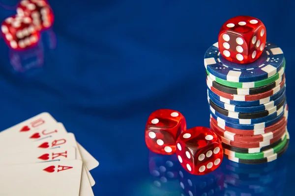 Fichas de jogo e cartão de poker no fundo do espelho azul — Fotografia de Stock
