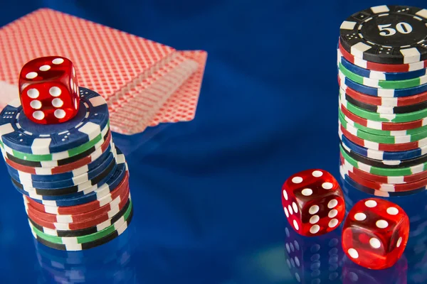 Fichas de jogo e cartão de poker no fundo do espelho azul — Fotografia de Stock