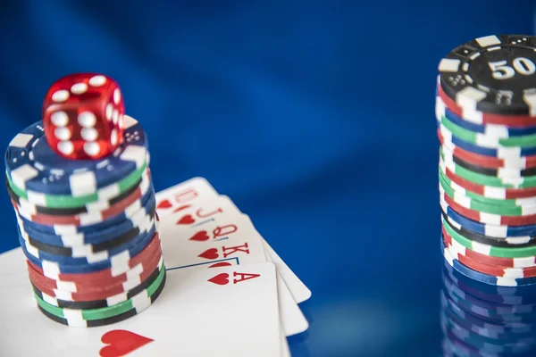Азартні фішки та покерна картка на фоні блакитного дзеркала — стокове фото