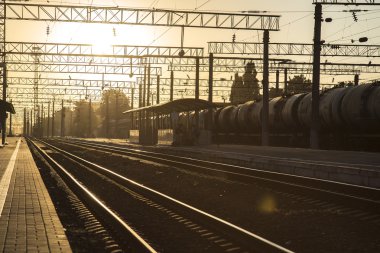Tren bir Binbaşı tren istasyonu güneş doğarken izler.