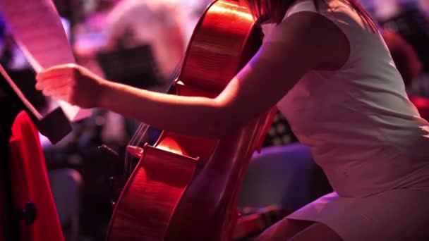 Concert, een vrouw in een korte jurk spelen van de cello. — Stockvideo