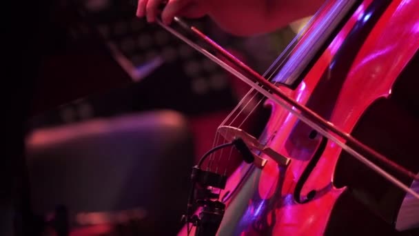 Concert, een man die het spelen van de cello, hand close-up. Panoramic schieten. — Stockvideo