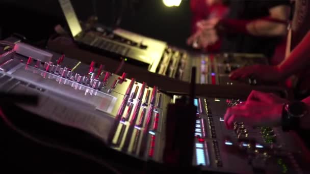 Manos masculinas y femeninas usando un mezclador digital de dos sonidos en un concierto — Vídeos de Stock