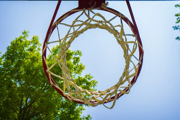 Basketball hoop from below looking up into the bright blue sky — Stock Photo, Image