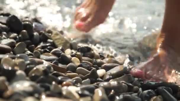 Piedi femminili con pedicure passeggiando nella spiaggia di mare ghiaiosa — Video Stock