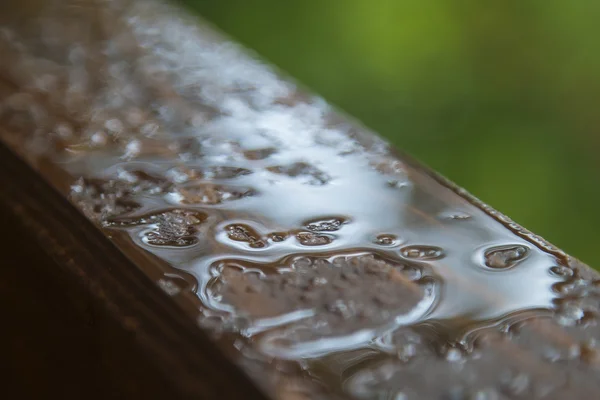 Gotas de lluvia en un alféizar de madera — Foto de Stock