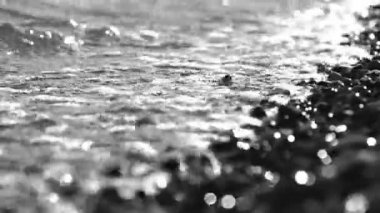 Yakın çekim renksiz dalgalar ve damla agains bir çakıl plajı alan sığ derinliği ile alıştırma.