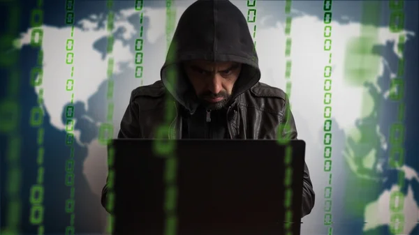 Hacker en una capucha con portátil. Peligro red en línea . — Foto de Stock